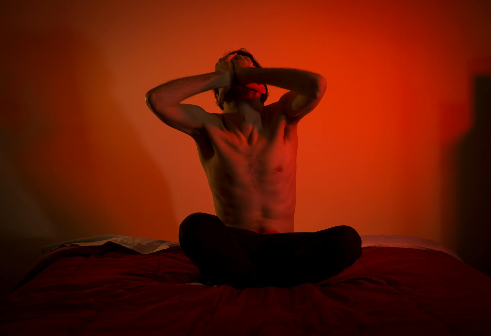 topless man sitting on the bed