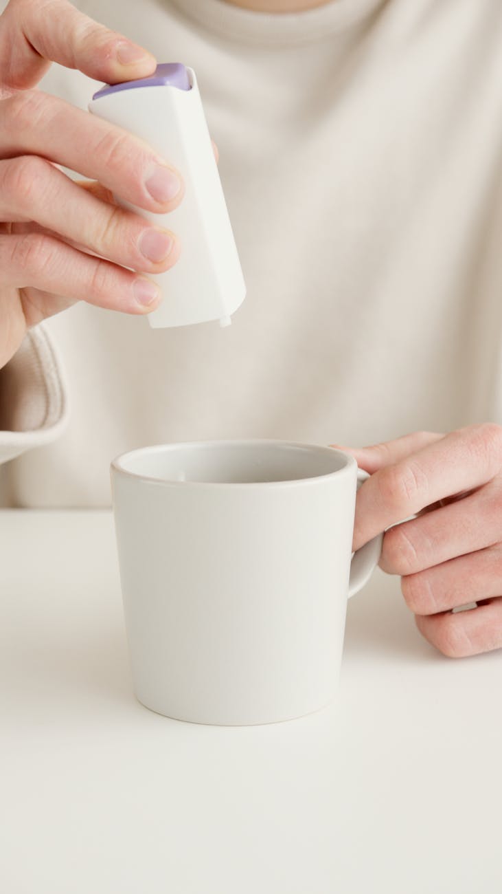 person using a glucometer with a ceramic cup