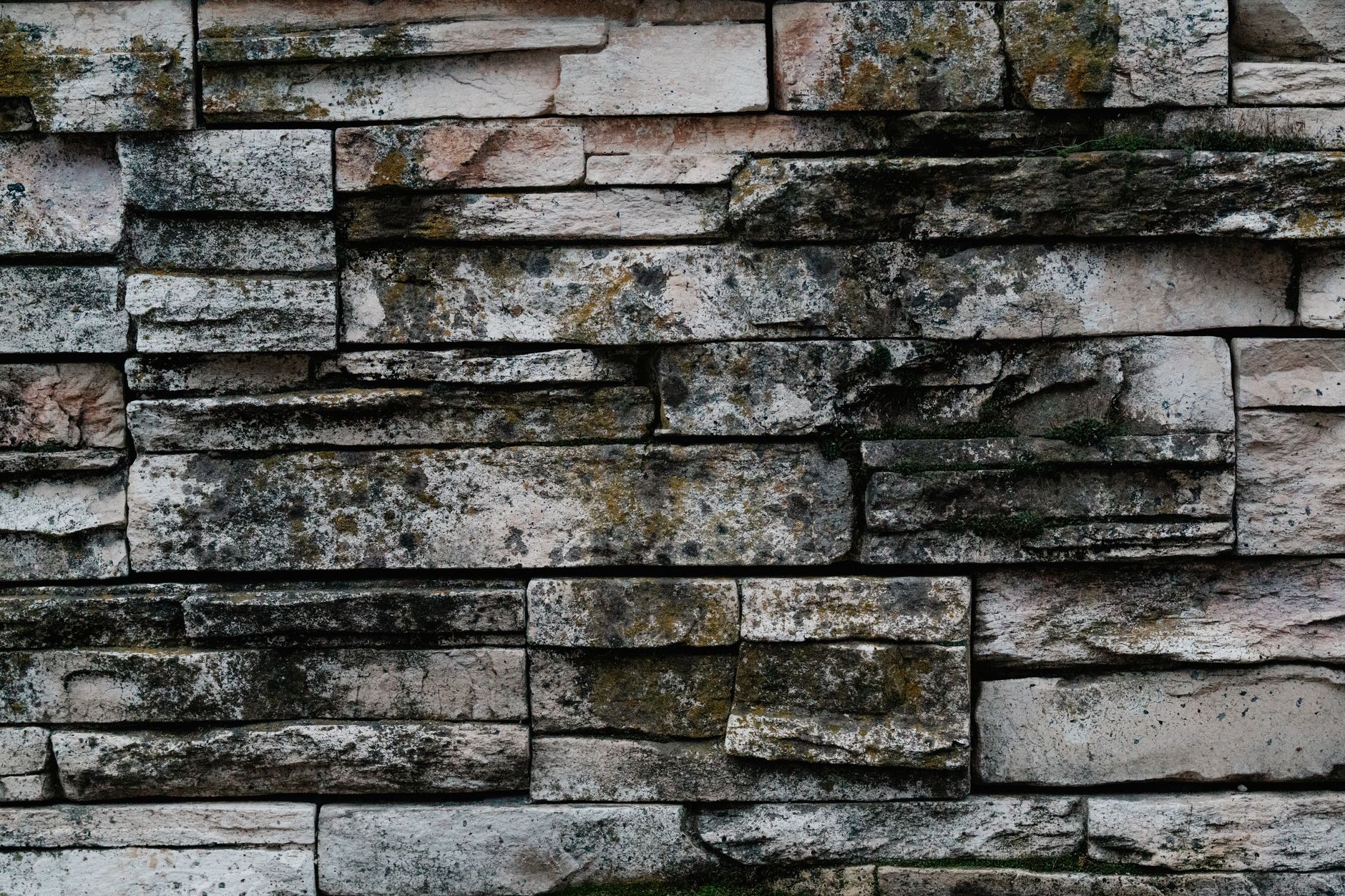 textured stone wall with moss and lichen